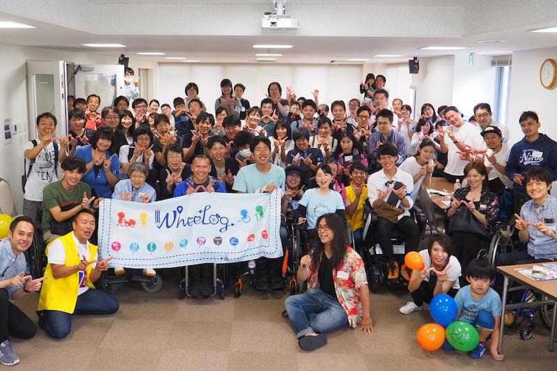 wheelog!の旗を中心にほほ笑む40人ぐらいの人々