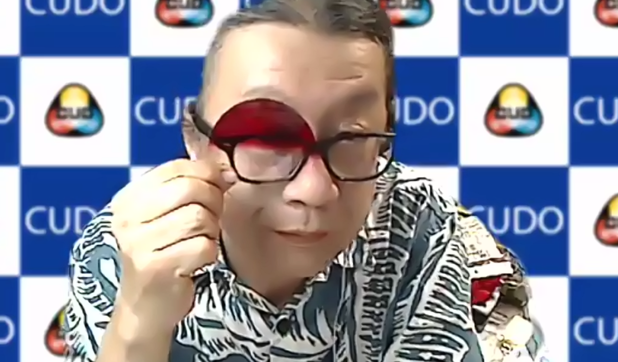 伊賀さんが赤いカラーフィルターから目をのぞかせている、バストアップ写真